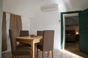 a dining room with a wooden table and chairs at B&B Masseria del Marchese in Castellana Grotte +67 photos