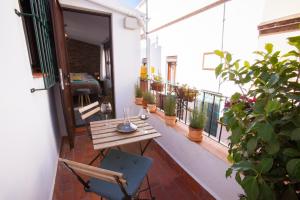 a patio with a wooden table and chairs on a balcony at Lukanda Casa de las Especias in Seville