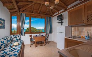 a kitchen and living room with a couch and a table at Kamares House Apartments & Studios in Vourvourou
