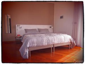 1 dormitorio con 1 cama grande y edredón blanco en B&B Susanna, en Cavaion Veronese