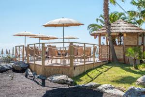 a resort with a deck with chairs and umbrellas at Aregai Marina Hotel & Residence in Santo Stefano al Mare