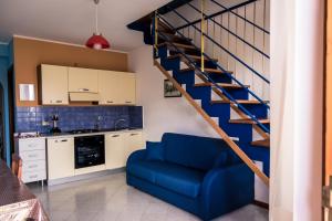 un salon avec une chaise bleue et un escalier dans l'établissement Residence Azzurro Calaghena, à Montepaone