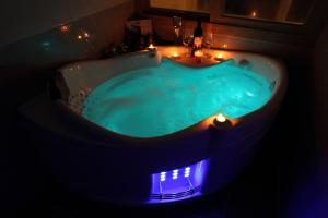 a blue tub with lights in a bathroom at Jeju the Ocean Hill Pension in Seogwipo