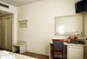 a room with a desk and a mirror on the wall at Hotel Colaiaco in Anagni