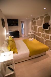 una camera con un grande letto e un muro di pietra di Historical Porto Studios a Porto
