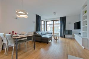 salon ze stołem i kanapą w obiekcie Imperial Apartments - Sopocka Przystań w mieście Sopot