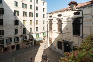 une personne marchant dans une allée entre deux bâtiments dans l'établissement Ghetto Apartment for 4, à Venise
