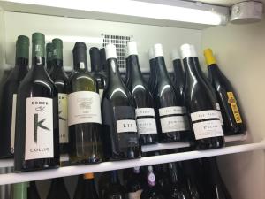 un montón de botellas de vino en un estante en Affittacamere Prosciutti Picaron, en Villanova