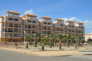 a large building with palm trees in front of it at Ribera Beach 3 - 2706 in Mar de Cristal