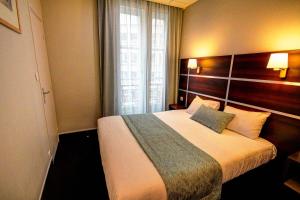 Una habitación de hotel con una cama grande y una ventana. en Hôtel Des Trois Gares, en París 29 fotos más