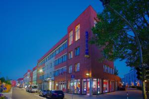 ein rotes Backsteingebäude an einer Straßenseite in der Unterkunft Hoteltow in Teltow