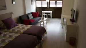 a bedroom with a bed and a couch and a table at Dream Studio in Las Canteras in Las Palmas de Gran Canaria