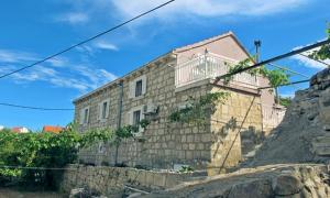 a stone house with a balcony on top of a hill at Studio Silvana & Room Renata in Lumbarda