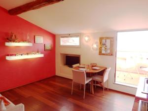 a dining room with red walls and a table and chairs at Mansarda Laura in Lerici