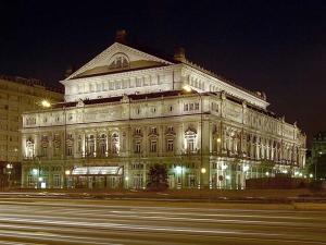 a large building is lit up at night at Corrientes y Uruguay in Buenos Aires