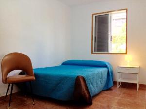 a bedroom with a bed and a chair and a window at Casa Miramar in Santa Cruz de Tenerife