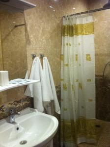 モスクワにあるHotel Compasのバスルーム(シンク、シャワー、タオル付)