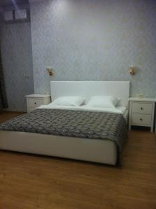 モスクワにあるHotel Compasのベッドルーム1室(白いベッド1台、ナイトスタンド2台付)