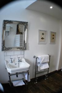 baño con lavabo, espejo y silla en The Bowl Inn, en Charing