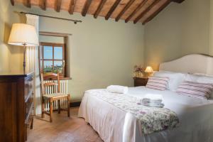 a bedroom with a bed with a table and a window at Borgo dé Brandi in Monteriggioni