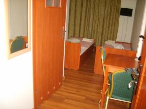 a room with a table and a bedroom with a bed at Pensjonat BorowaDolina in Osie