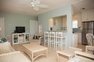 a living room with a table and chairs and a kitchen at Royal Flamingo Villas in Hillsboro Beach