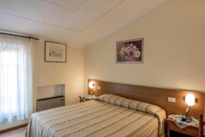 Postel nebo postele na pokoji v ubytování Albergo La Foresteria