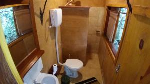 ein kleines Badezimmer mit Toilette und Waschbecken in der Unterkunft Pedra Escondida in Imbituba