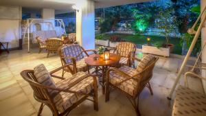 un patio con mesa y sillas y un jardín en Zina Hotel Apartments, en Atenas
