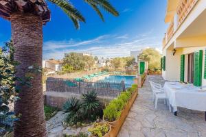 a villa with a swimming pool and a palm tree at Can Sard in Portocolom