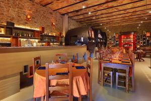 a restaurant with tables and chairs and a bar at Logis Auberge Du Vigneron in Cucugnan
