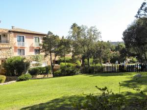 un cortile con recinzione e una casa di Residence Gardens a Porto Rotondo