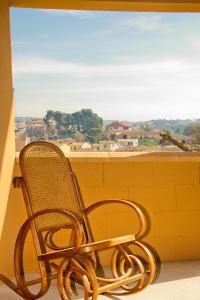 a chair sitting on a balcony looking out a window at Casa Codeta in La Almunia de San Juan