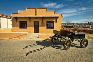 una carrozza trainata da cavalli di fronte a una casa di Casa Codeta a La Almunia de San Juan