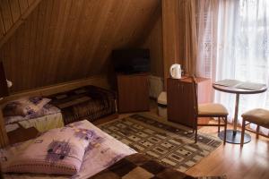 a bedroom with two beds and a table and a television at Willa Bartek in Ciechocinek