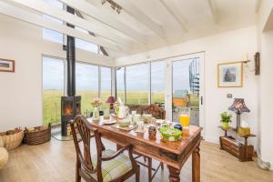 a dining room with a table with chairs and a fireplace at Tarskavaig Bed & Breakfast in Radernie