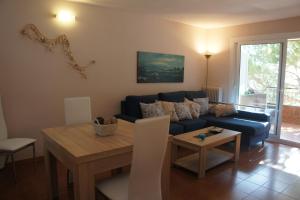 a living room with a blue couch and a table at Musclera in Arenys de Mar