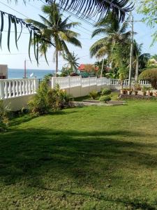 een wit hek in een tuin met de oceaan op de achtergrond bij Medellin Seaview Inn in Medellin