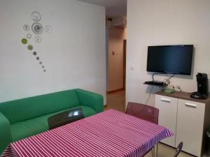 a living room with a green couch and a table at Apartments Pongrac in Cres