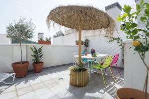 a patio with a table and chairs and an umbrella at Historic Centre + Rooftop + Parking in Málaga