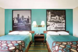 a hotel room with two beds and a picture on the wall at Pittsburgh Royal Hotel in Moon Township