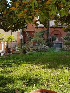 a house with a yard with green grass and a tree at Il Giardino Segreto di Ascoli Piceno in Ascoli Piceno