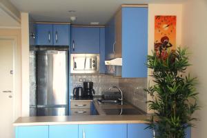 a kitchen with blue cabinets and a sink at MuchoSol in Benidorm