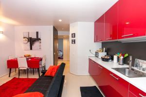 kuchnia i jadalnia z czerwonymi szafkami i stołem w obiekcie Ana's Design Apartments w Lizbonie