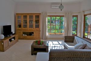 a living room with a couch and a tv at Villa Nirwana in Lovina