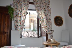 Cette chambre dispose d'une fenêtre avec des rideaux et une table. dans l'établissement Catherine's Home, à Rome