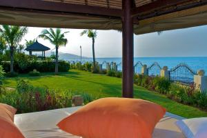 a bed with pillows and a view of the ocean at Villa Nirwana in Lovina