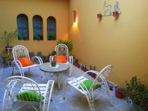 a patio with chairs and a table and a table and chairs at Hostal Alamo in Cafayate