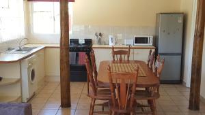 a kitchen with a table and chairs and a refrigerator at Ras Vill in Glencairn