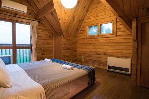 a bedroom with a bed in a log cabin at Balls Deep Inn Villas in Hakuba